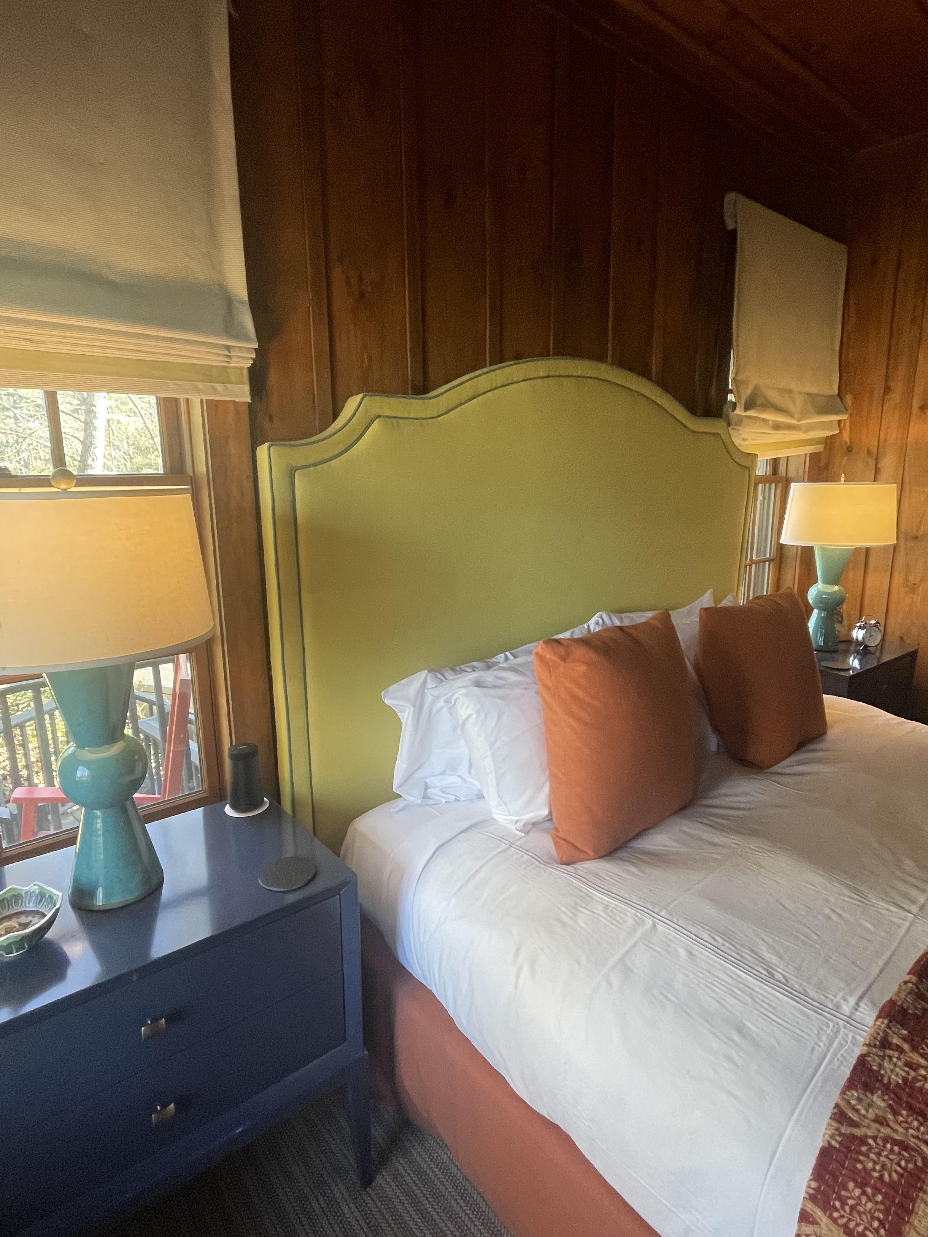 A comfy bed stacked with pillows in a well-lit room at High Hampton Resort.
