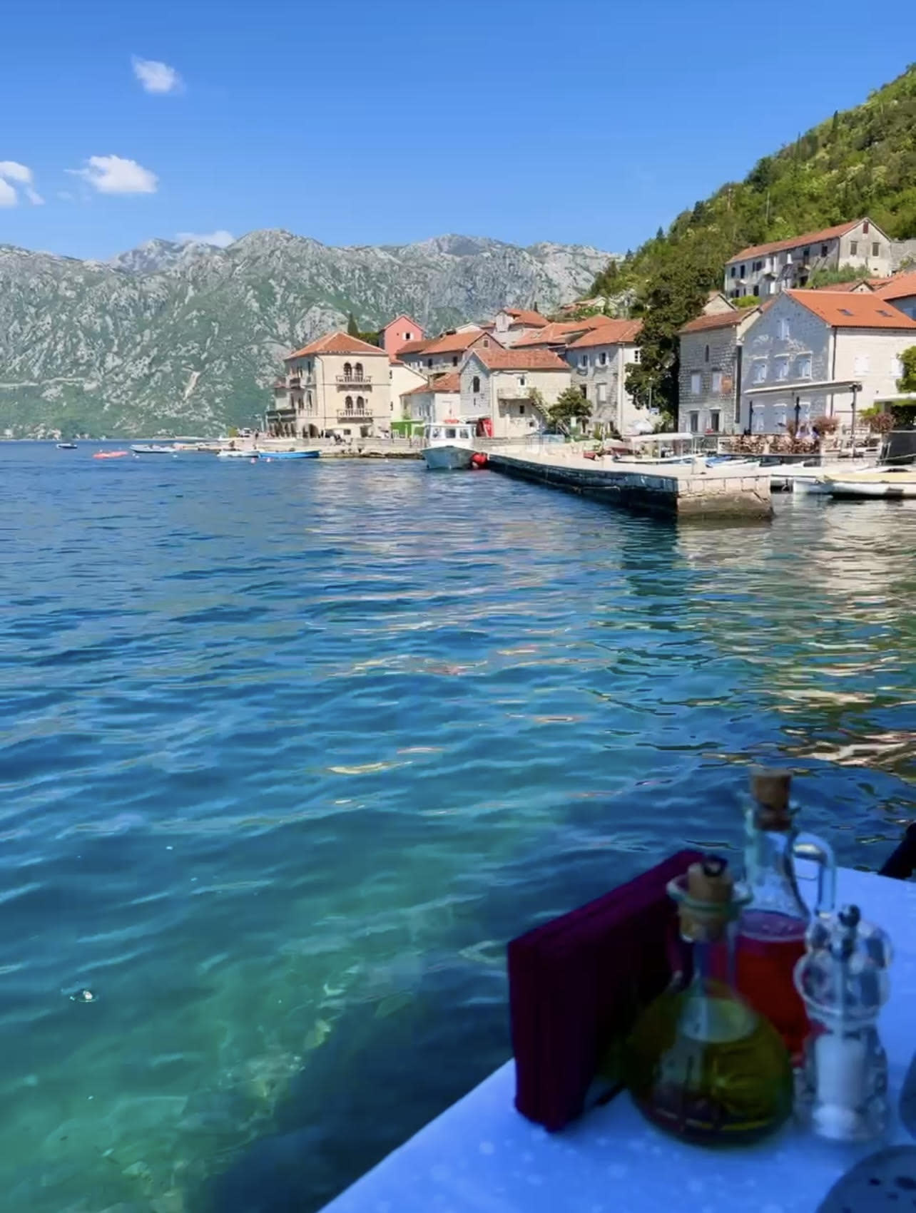 A captivating view of the blue seas with green mountains and orange-roof buildings in Croatia.