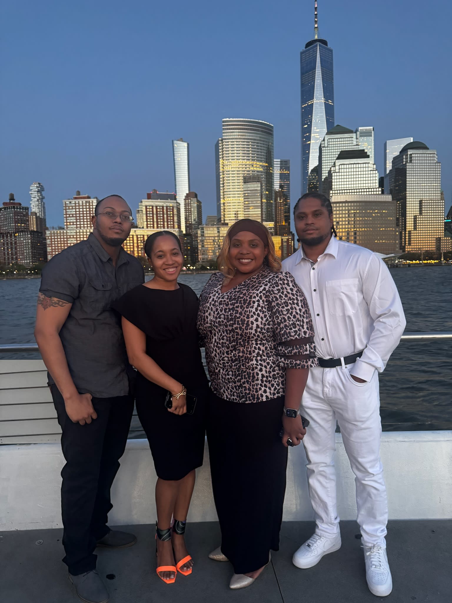 A group of people standing with a city view at night.