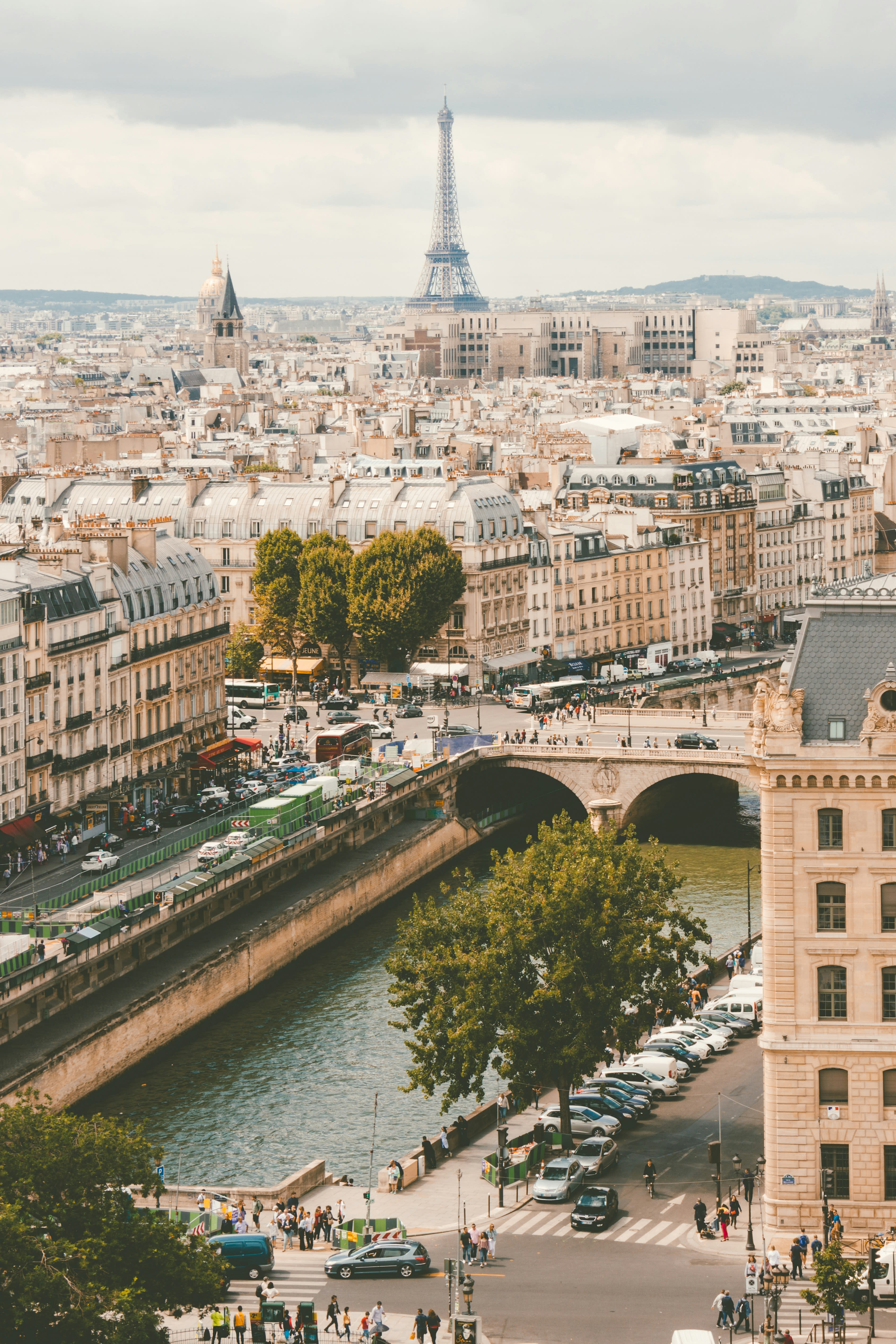 An aerial photo of Paris, over the Seine River with the Eiffel Tower in the distance.