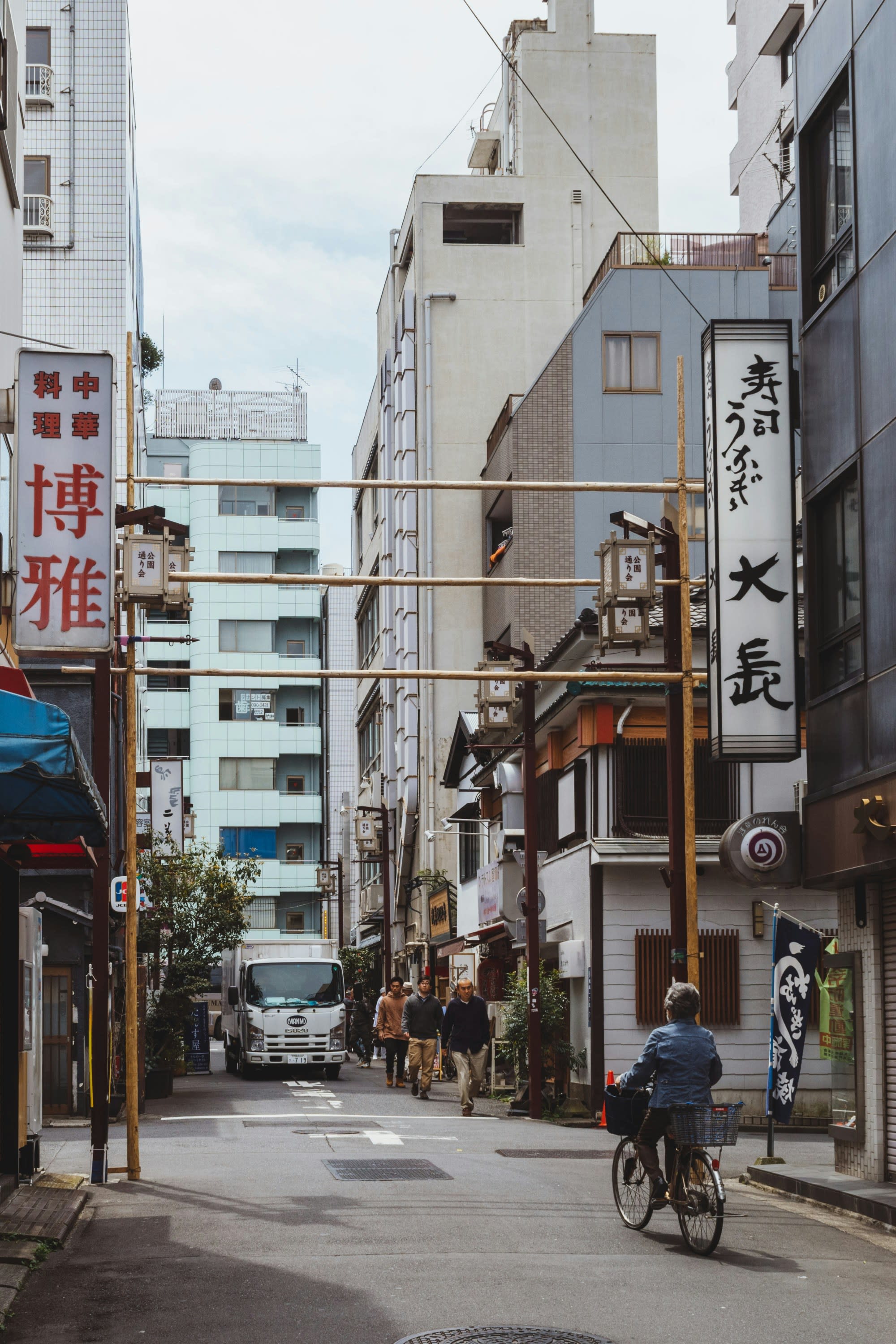 People walking and cycling on a city street in Japan