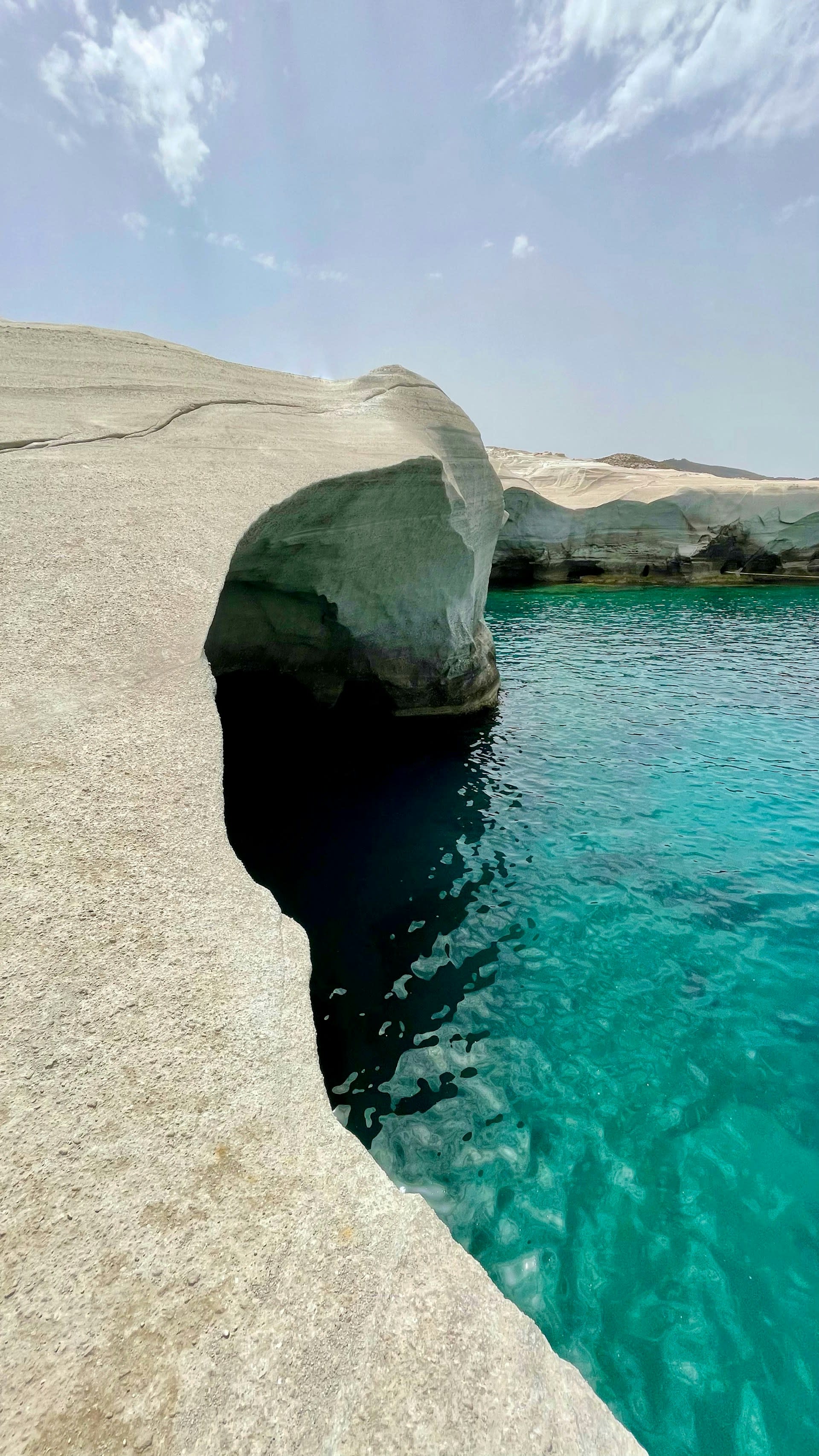 White rock formation next to blue water during the daytime