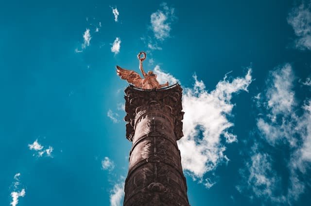 A low-angled photo of a statue during the daytime