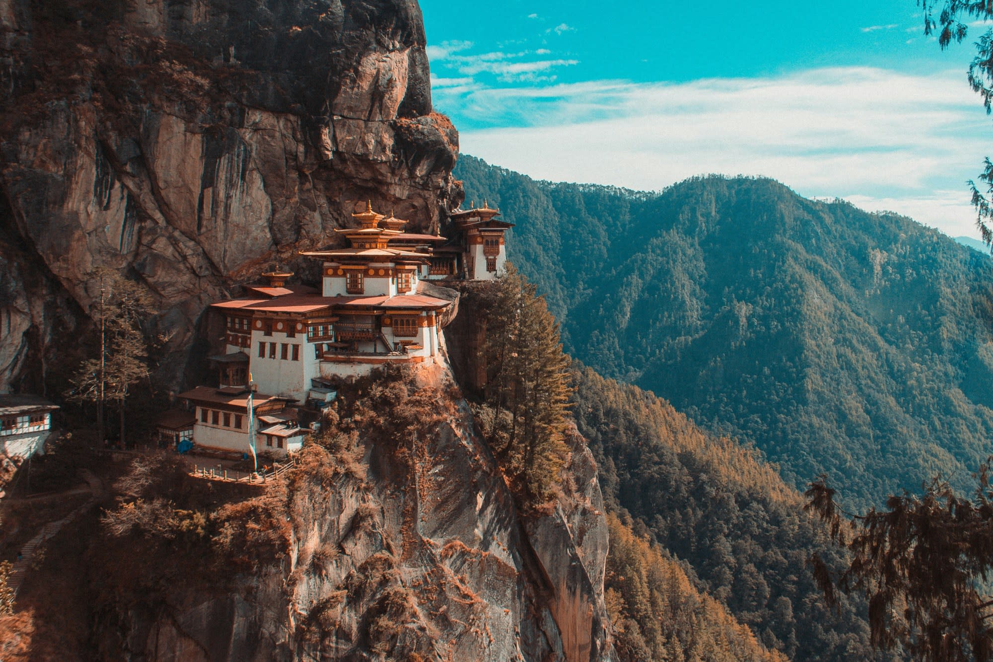A scenic view of Tiget's Nest Monastery nestled on the edge of a cliff in Bhutan.