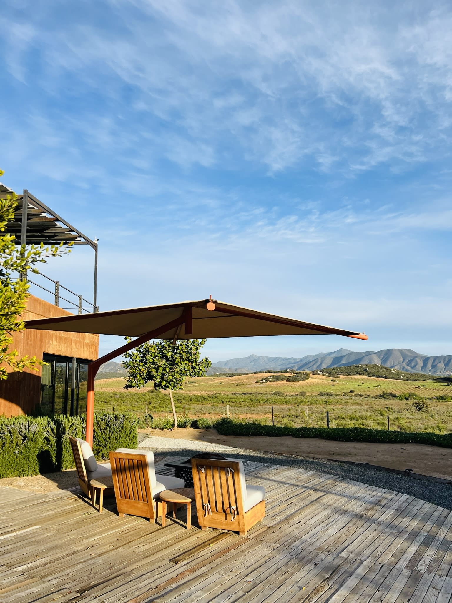 View of valley with lounge chairs on a patio.