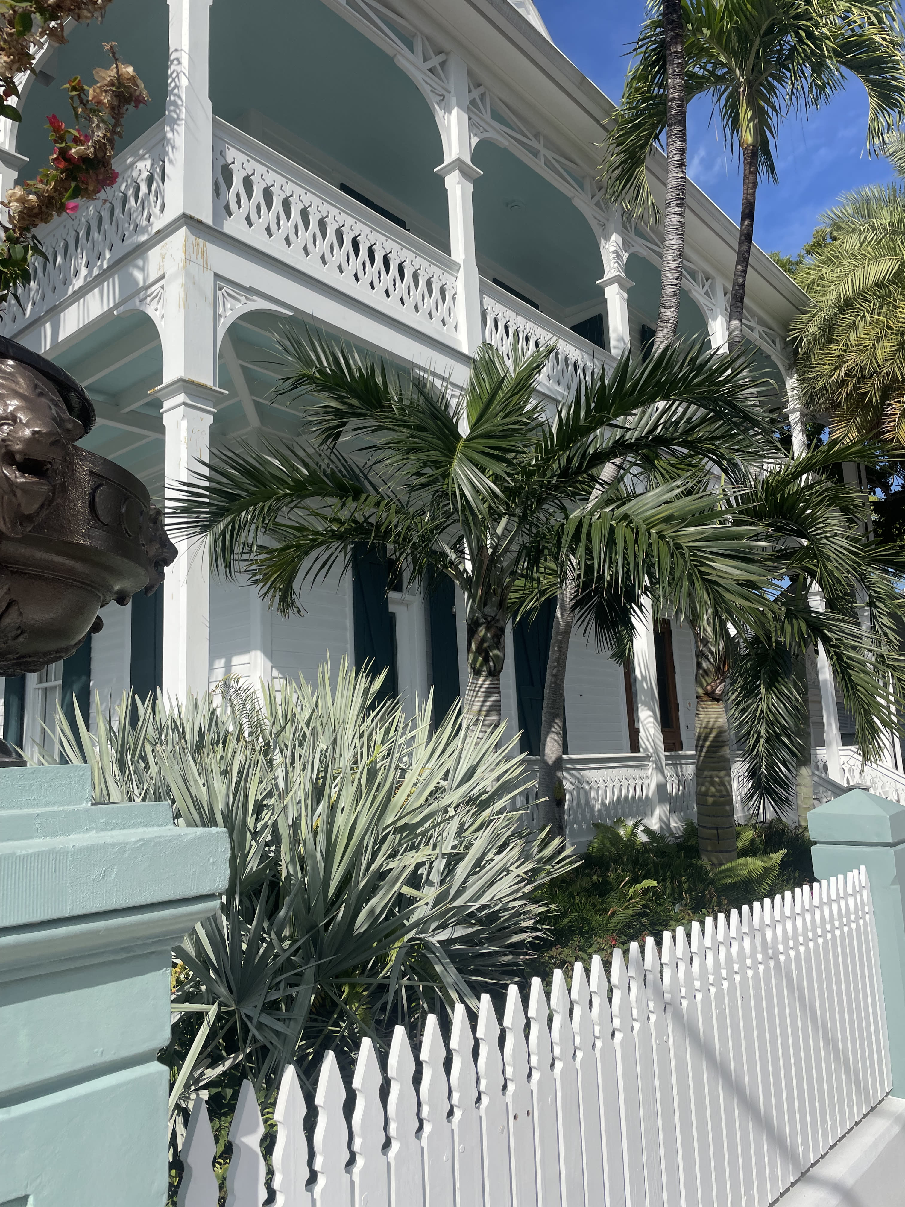 The facade of the historic inn Winslow's Bungalows with white fence and white exterior