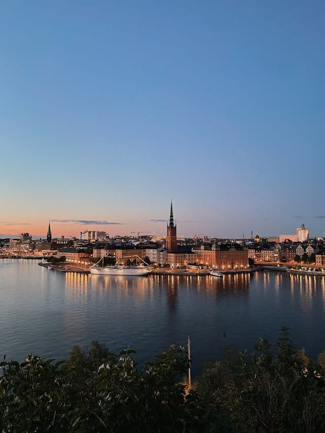 A view of a city next to a body of water at dusk.
