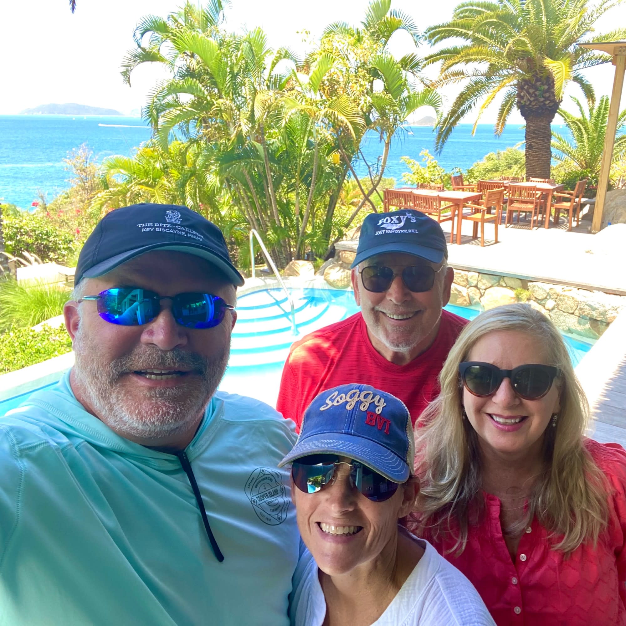 Group of people in a resort in front of a pool.