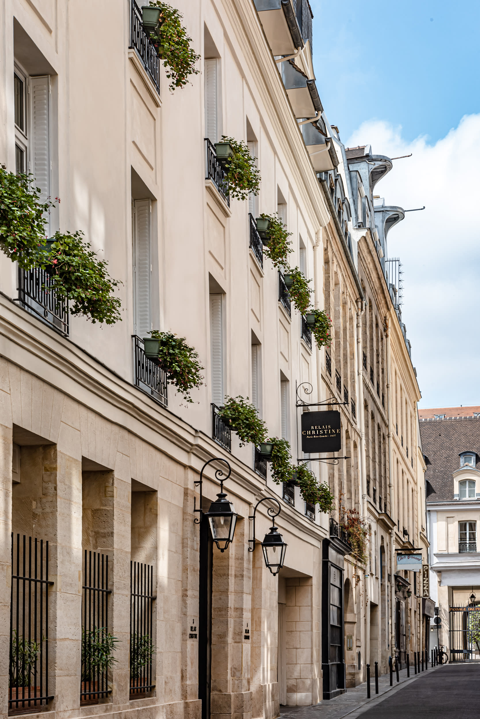 The Relais Christine hotel in the 6th arrondissement of Paris, a beige building with green plants on the balconies.