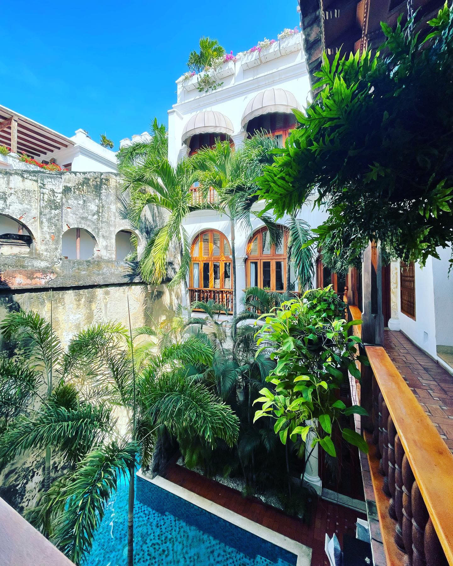 colorful courtyard with a pool and greenery